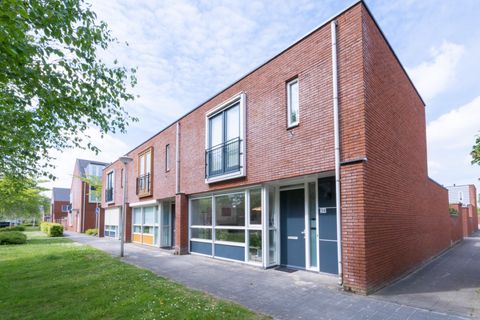 Bakstenen woning met frans balkon aan de Vadinushof in De Meern, met een rij berken op het gras ervoor