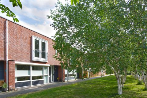 Bakstenen hoekwoning met grote raampartij en frans balkon aan de Vadinushof in De Meern