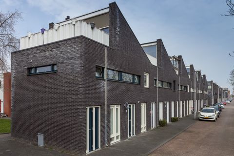 Rij moderne woningen van donkere baksteen met dakterrassen aan de Houtrakgracht in Utrecht