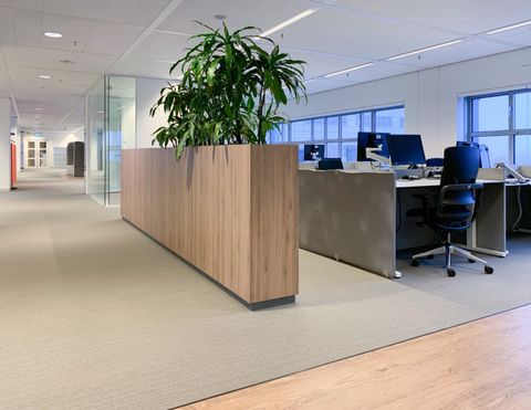 Werkplekken aan het raam met een houten plantenbak op de voorgrond