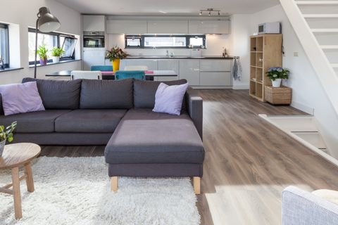Open woonkamer met hoekbank, met de keuken op de achtergrond