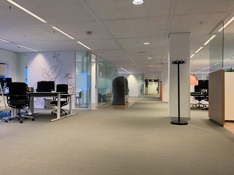 Open kantoorvloer met werkplekken en glazen wanden